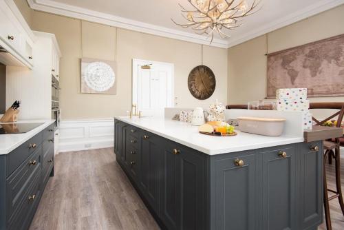 a kitchen with blue cabinets and a white counter top at Linen House in Kelso