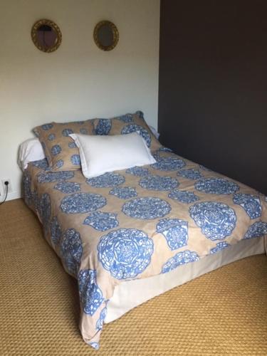 a bedroom with a bed with a blue and white blanket at Chez Sylvie in Saint-André-des-Eaux