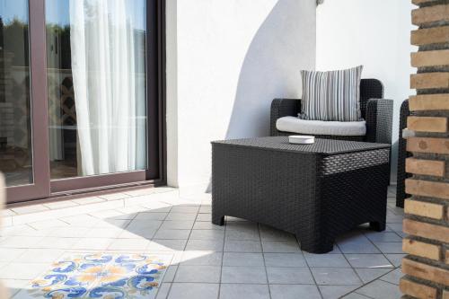 a chair and a table on a patio at Paradise Sicily Rooms in Calatabiano