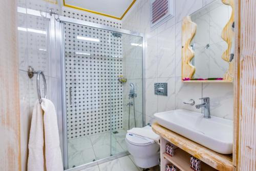 a bathroom with a shower and a sink and a toilet at Kaş Sun Glare Hotel in Kas