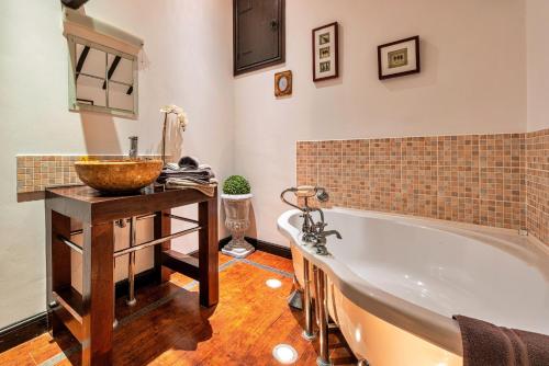 a bathroom with a bath tub and a sink at Finest Retreats - The Hayloft at Greystones in Swinderby
