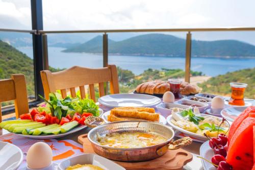 a table with food on it with a view of the ocean at Kaş Sun Glare Hotel in Kas