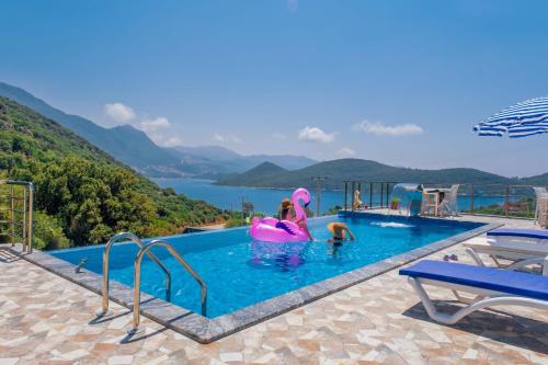 a swimming pool with two people in an inflatables in the water at Kaş Sun Glare Hotel in Kas