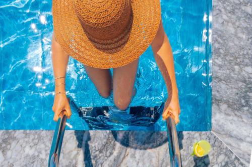 a woman in an orange dress sitting on a chair in a swimming pool at Kaş Sun Glare Hotel in Kas