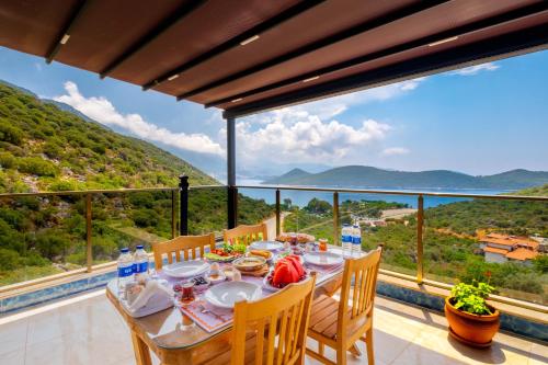a dining room with a table and chairs on a balcony at Kaş Sun Glare Hotel in Kas