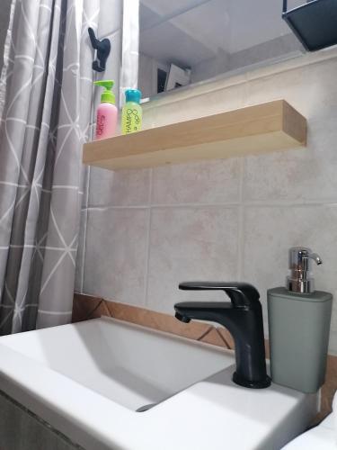 a bathroom with a sink and a shower curtain at petite nafplio sofos apartment in Nafplio