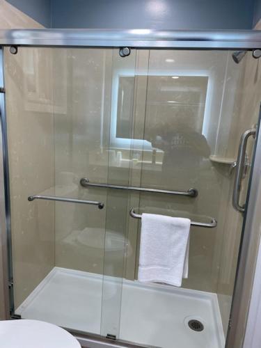 a glass shower with a white towel in a bathroom at Blue Seal Inn in Pismo Beach
