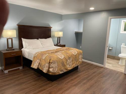 a bedroom with a bed and two night stands with lamps at Blue Seal Inn in Pismo Beach