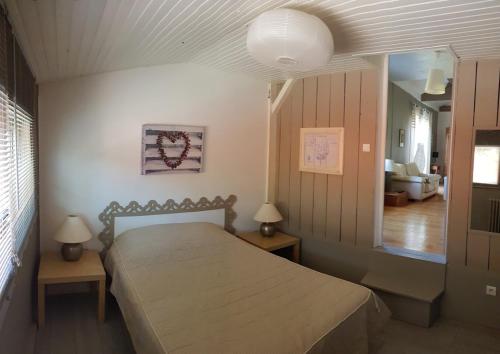 - une chambre avec un lit, deux tables et un miroir dans l'établissement Confort et charme à 4km d'Arcachon centre, à La Teste-de-Buch