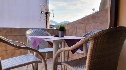 a table and chairs on a balcony with a purple table cloth at Rodon Garden Centre in Sarti