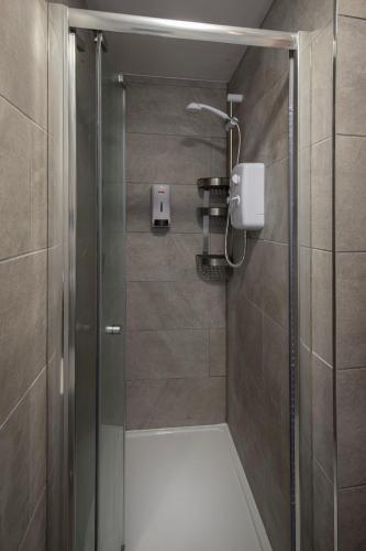 a shower with a glass door in a bathroom at Jellyfish Apartments in Blackpool