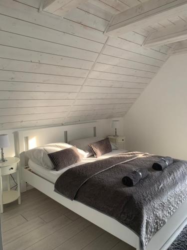 una camera con un grande letto e un soffitto in legno di Szőlőskert vendégház a Balatonszőlős