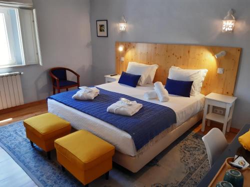 ApraHouseLoule Guesthouse في لولي: غرفة نوم بسرير كبير عليها مناشف