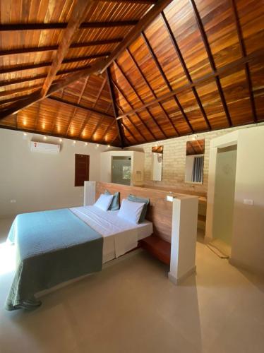 a bedroom with a large bed with a wooden ceiling at Vila Palmeiras in São Miguel do Gostoso