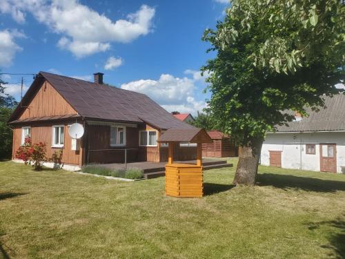 a house with a tree in front of it at Domek pod Lipą in Narol