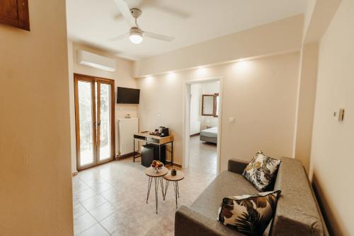een woonkamer met een bank en een tafel bij Sun Touch Pelion Rooms in Kala Nera