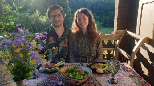 a man and a woman sitting at a table with food at Amatų kalnelis in Anykščiai