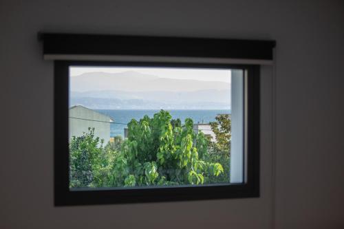 a window in a room with a view of the ocean at Amarynthos Maisonettes in Amarinthos