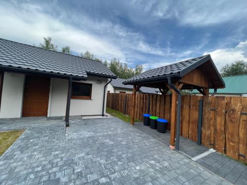 a house with a wooden fence and a patio at Domek -Radawa-Królewska 77b,domek Dorota in Radawa