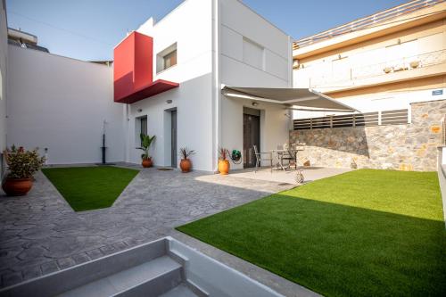 a courtyard of a house with green grass at Amarynthos Maisonettes in Amarinthos