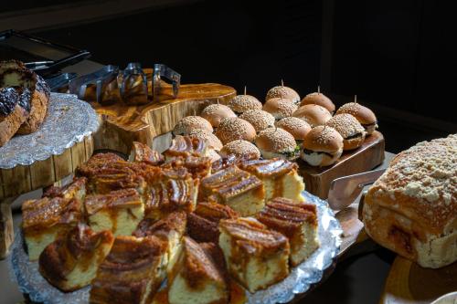 a display of different types of bread and pastries at Hotel Laghetto Fratello in Gramado