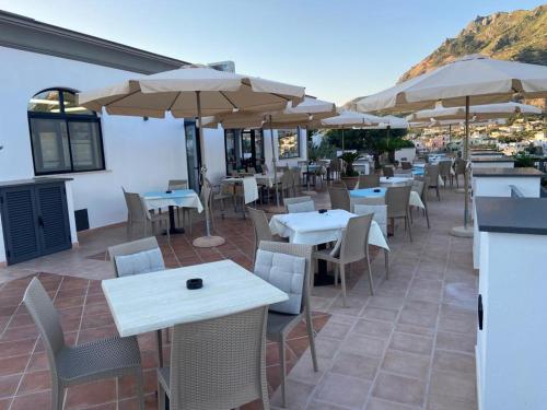 a restaurant with tables and chairs and umbrellas at Residenz e Ristorante da Mimì in Ischia