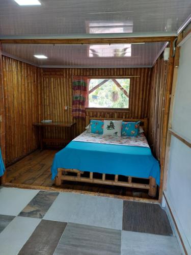 Cama en habitación pequeña con ventana en El Encanto Nature Reserve, en Palestina