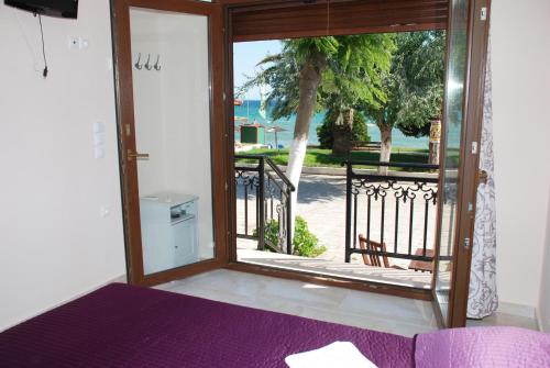 a room with a door open to a balcony at Melidron in Nea Roda