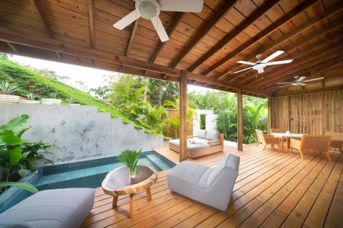 a patio with a wooden deck with a ceiling fan at Ibagari Boutique Hotel in Roatan
