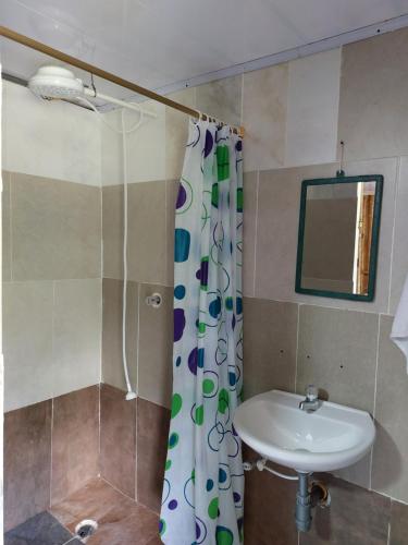 a bathroom with a sink and a shower curtain at El Encanto Nature Reserve in Palestina