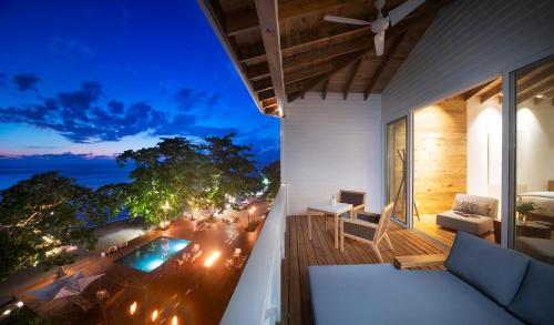 a balcony with a view of a city at night at Ibagari Boutique Hotel in Roatan