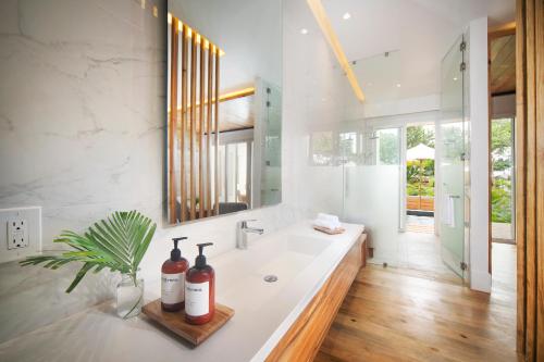 a bathroom with a sink and a large mirror at Ibagari Boutique Hotel in Roatan