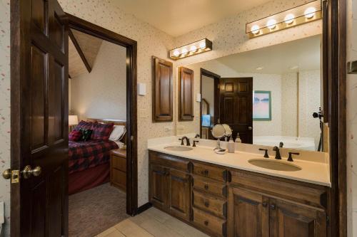 a bathroom with a sink and a mirror and a bed at Cascade Village 50 Near Purgatory - Marmot Meadows Retreat in Durango Mountain Resort