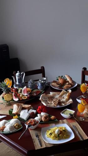 uma mesa com muitos pratos de comida em Jal,Min Homestay em Kandy