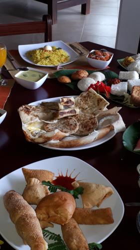 a table with plates of food on top at Jal,Min Homestay in Kandy
