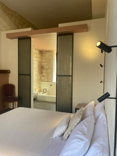 a bedroom with a white bed and a bathroom at Casa di Melo - Organic Country Hotel in Cassibile