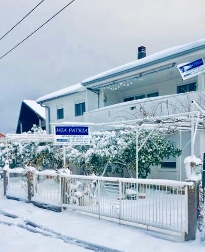 a house with a white fence in the snow at Apartments Mia Patria in Ulcinj