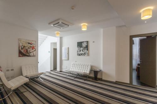 a living room with two chairs and a rug at Hotel Nazionale in Ferrara