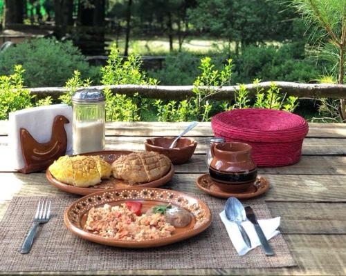 a wooden table with plates of food on it at Rancho Cumbre Monarca in La Ciénega