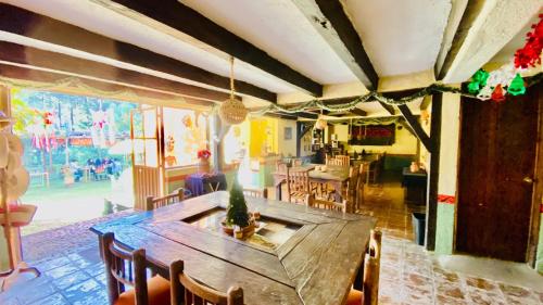 uma sala de jantar com uma mesa de madeira e cadeiras em Rancho Cumbre Monarca em La Ciénega