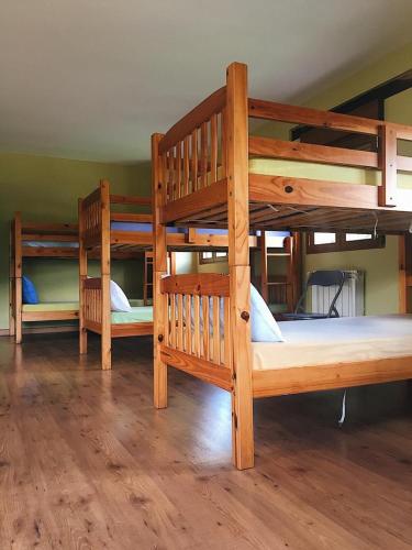 three bunk beds in a room with wooden floors at Albergue de peregrinos Santa Marina in Molinaseca
