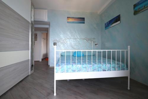 a white crib in a room with a wall at Una Conchiglia sul Mare Attico vista Portofino in Zoagli