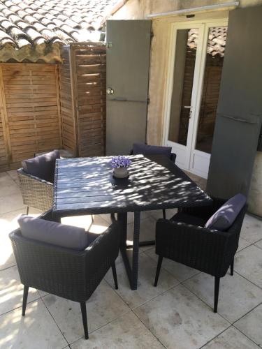 a black table and chairs with a table and a table and chairs at Juste derrière chez nous in Boulbon