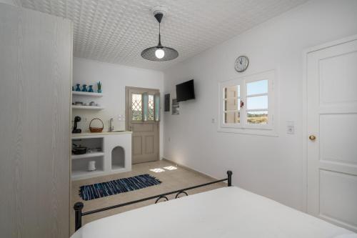 a white bedroom with a bed and a window at Amato in Mandrakia