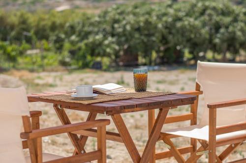 a wooden table with two chairs and a cup and a book at Amato in Mandrakia