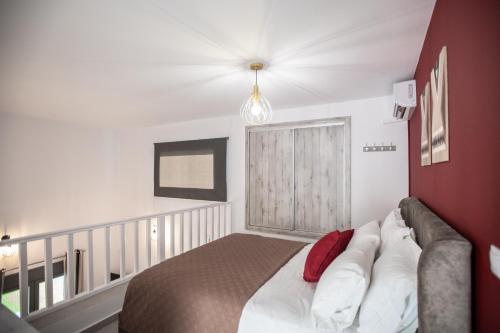 a bedroom with a bed and a red wall at Amarynthos Maisonettes in Amarinthos