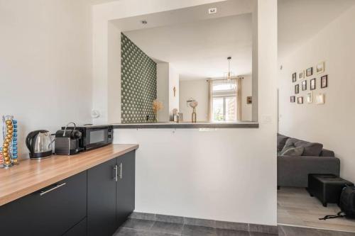 une cuisine avec un comptoir et un salon dans l'établissement Appart'LH - Stationnement gratuit - B'PAM, au Havre