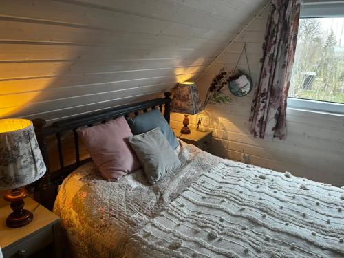 a bedroom with a bed with pillows and a window at Domek Anuszka in Sztutowo