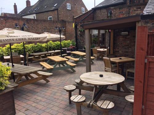 a patio with wooden tables and benches in a restaurant at The Rose & Crown York in York