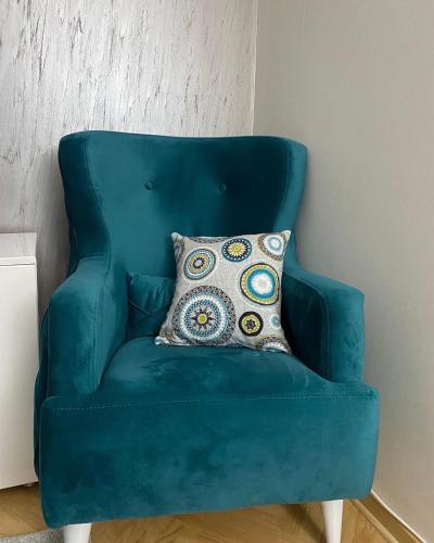 a blue chair with a pillow in a room at Dora Lux & Free Indoor Parking in Vrnjačka Banja